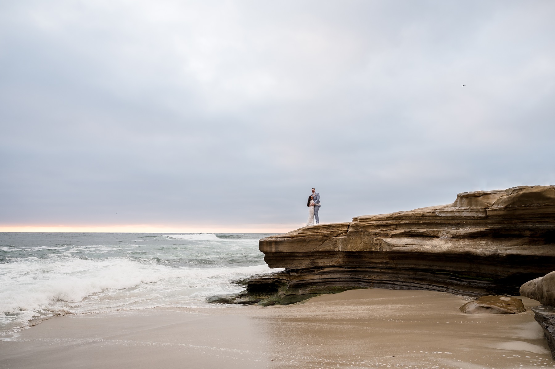 Bride and groom on cliffs by ocean Southern California Wedding Photos