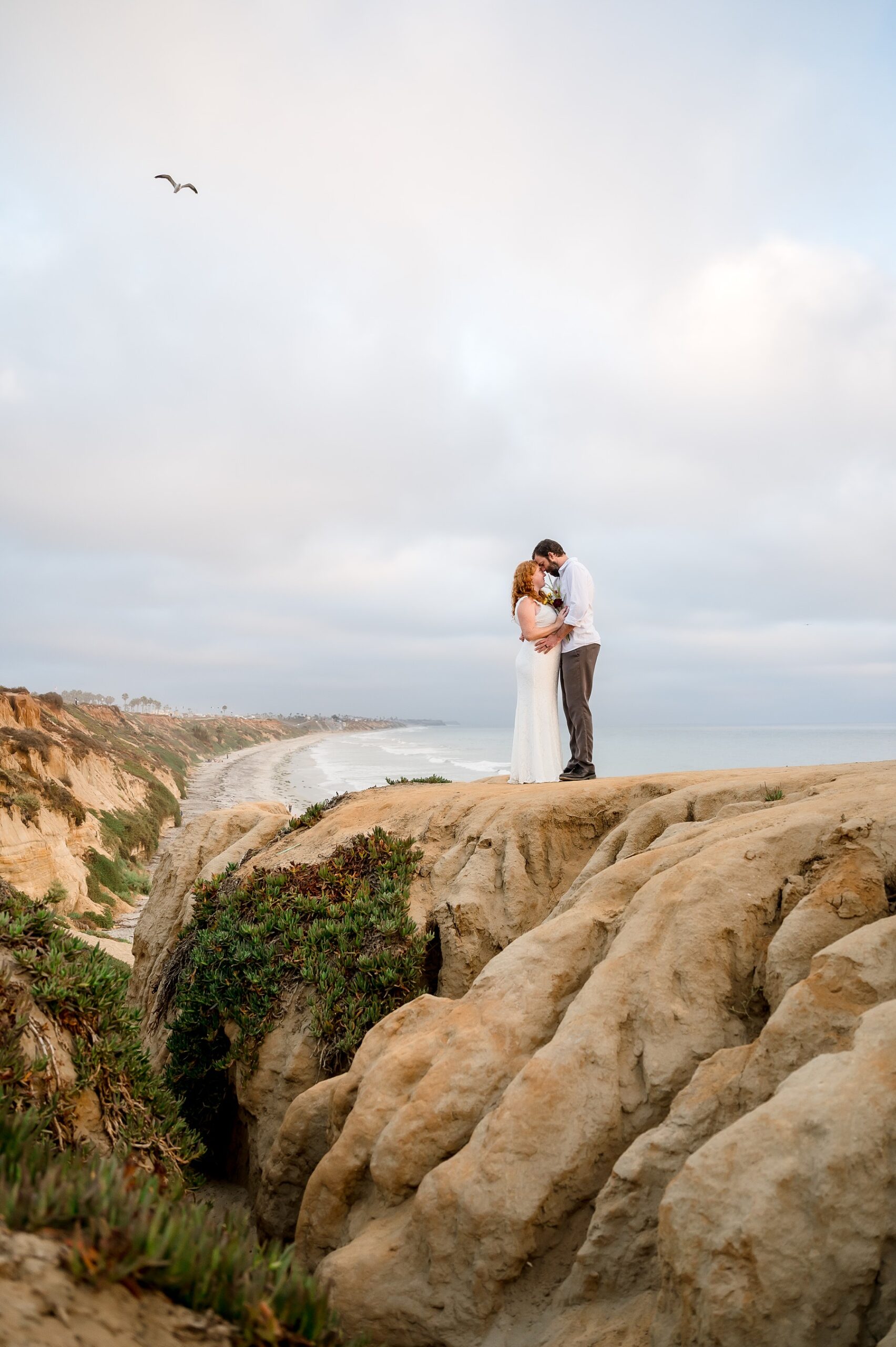 Bride and groom on Cliffs by ocean Southern California Wedding Photos